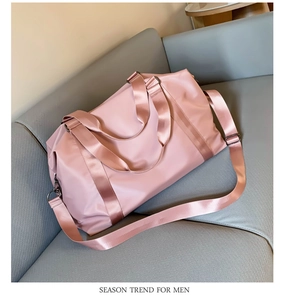Close-up of pink waterproof travel bag with black metal hooks and nylon straps