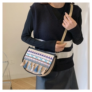 Ethnic crossbody bag featuring colorful embroidery, tassels and textured linen fabric