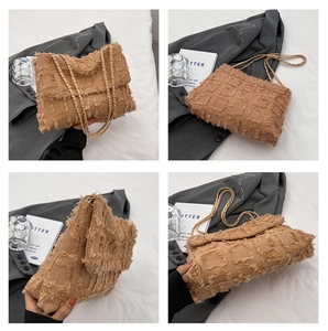 Detail view of light brown plush shoulder bag with grid texture and chain straps