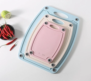 Three-piece wheat straw cutting board set with non-slip pads in blue, beige and pink