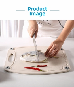 Detail of wheat straw cutting board with non-slip pads used for preparing fish and peppers