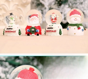 Detail of four festive Christmas crystal balls with Santa Claus and Snowman resin base