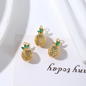 Detailed close-up of three 18K gold plated pineapple pendants with sparkling zircons