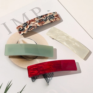 Sélection de pinces à cheveux en acétate écaille et vert sauge sur magazine de mode