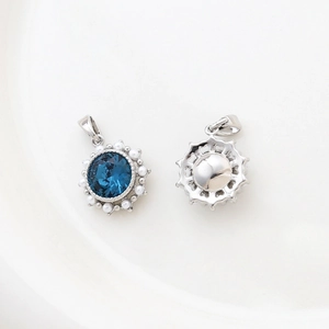 Detail showing front and back of 14k gold plated flower pendant with blue stone and pearls