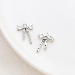 Macro detail of silver bow pendant with cubic zirconia inlay for DIY jewelry design