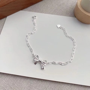 Close-up of S925 sterling silver bow chain bracelet featuring a delicate heart charm