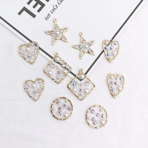 DIY jewelry pendants with gold borders, white faux pearls and sparkly rhinestones