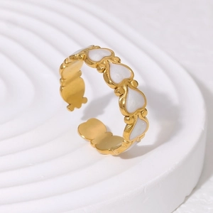 Detail of minimalist 18K gold plated heart ring with white enamel accents on stand