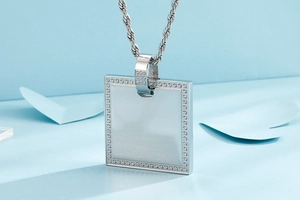 Macro view of silver square CNC zircon pendant with rope chain on light blue background