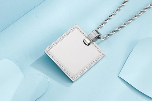Detail of square silver pendant necklace with CNC inlaid cubic zirconia on blue background