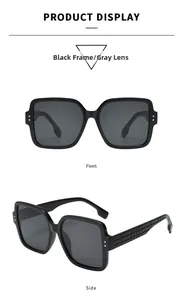 Macro detail of oversized square sunglasses featuring textured black temples and gray lenses