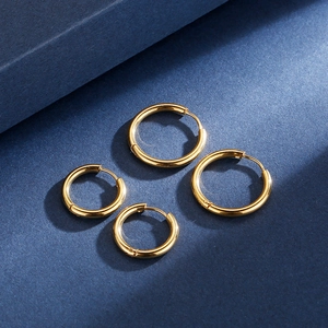 Classic gold titanium steel hoop earrings in various sizes on a dark blue texture