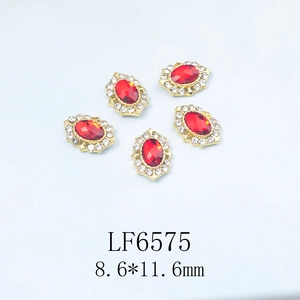 Détail de bijoux d'ongles ovales rouges avec base dorée et strass, dimensions 8,6x11,6 mm