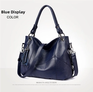 Detailed shot of dark blue leather bag with tassels and adjustable shoulder strap