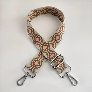 Close-up of ethnic jacquard woven shoulder strap with silver metal swivel hooks and buckles