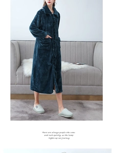 Detail view of long navy coral fleece robe with large pockets and lapel in cozy home setting