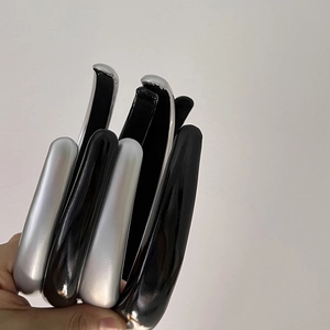 Padded vintage faux leather headbands in silver and black shown held by hand