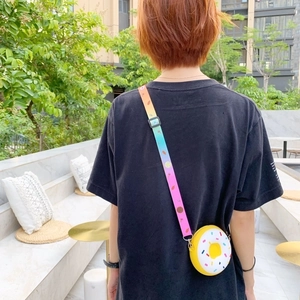 Detail of adjustable rainbow strap and silicone donut purse on a person