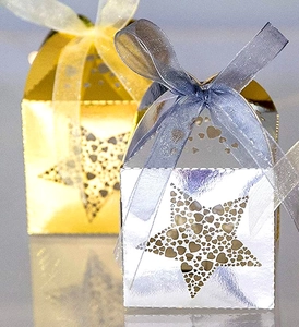 Close-up of gold and silver laser-cut star gift boxes with elegant organza ribbons