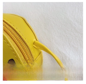 Detailed view of durable shoulder strap connection on bright yellow girls crossbody bag
