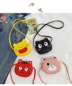 Detailed flat lay of cute cartoon cat mini crossbody bags in yellow, black, red, and pink