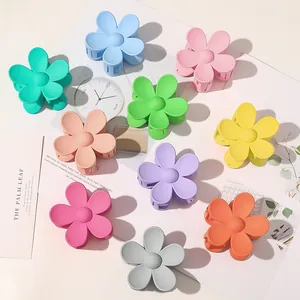 Flat lay of colorful matte flower hair claws in assorted macabre pastel candy colors