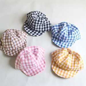 Collection of five colorful plaid cotton baseball caps for babies in a circular layout