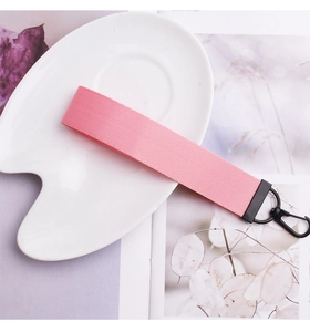 Détail de la lanière en nylon rose tissé avec mousqueton métallique rotatif noir mat
