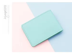 Detail of mint green card holder with lychee texture on a pink and blue background