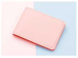 Detail of pink lychee leather card holder with fine stitching on colorful background