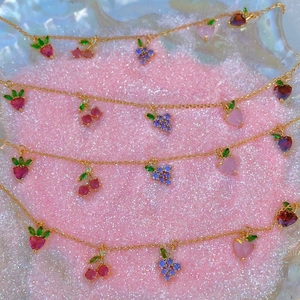 Colorful zircon fruit charm bracelets featuring cherry and peach pendants on gold chains