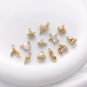 Detailed close-up of 14K gold plated ocean pendants including starfish and seashell charms