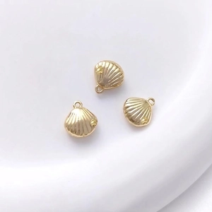 Detailed view of three 14K gold plated scallop shell charms for DIY jewelry making