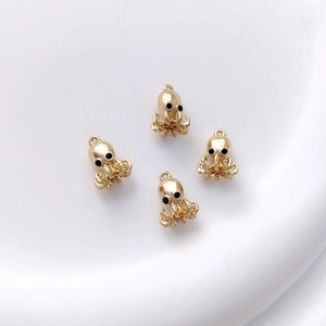 Macro detail of 14K gold-plated octopus jewelry charms with smooth metallic texture