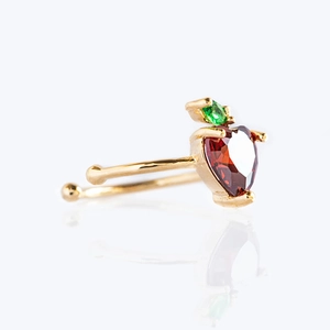 Detailed view of a strawberry gold ear cuff featuring vibrant red and green cubic zirconia