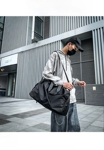 Macro shot of durable black nylon travel bag with heavy-duty handles and shoulder strap