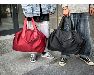 Outdoor shot of large capacity red and black nylon travel bags held by models