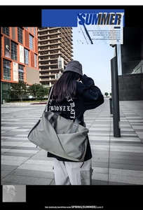 Model view of an oversized waterproof nylon sports travel bag with adjustable strap