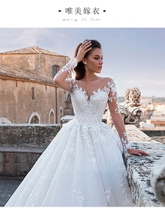 Detail of white long-sleeved lace wedding dress with V-neckline and floral embroidery