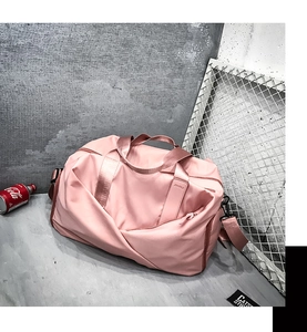 Detail view of pink nylon travel bag with pleated texture and adjustable strap