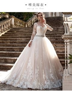 Détail du bustier en dentelle à manches longues et ceinture en strass sur la robe de mariée