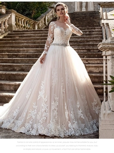 Détail des broderies sur les manches et ceinture perlée d'une robe de mariée