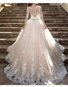Détail du dos d'une robe de mariée avec manches en dentelle illusion et dos transparent boutonné
