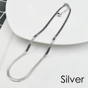 Detail of silver snake bone chain featuring a delicate heart pendant and adjustable clasp