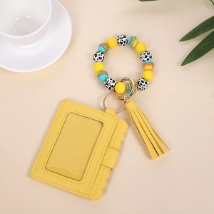 Detail of yellow wave-edge PU card holder with silicone bead wristlet and tassel