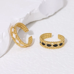 Detailed shot of gold plated stainless steel rings with black and white enamel drip