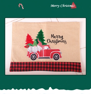 Close-up of burlap placemat with Merry Christmas print and red truck design