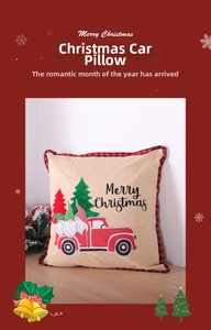 Detail of burlap pillow cover with vintage red truck embroidery and red plaid border