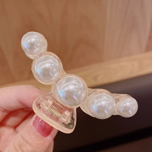 Close-up of pearl hair claw clip with transparent base and five faux pearls